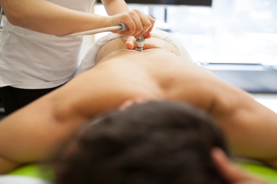fisioterapeuta usando el equipamiento técnico de presión y calor en estética Badalona Ana